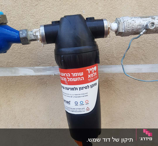 מסנן מים מחובר לצנרת עם תווית בעברית